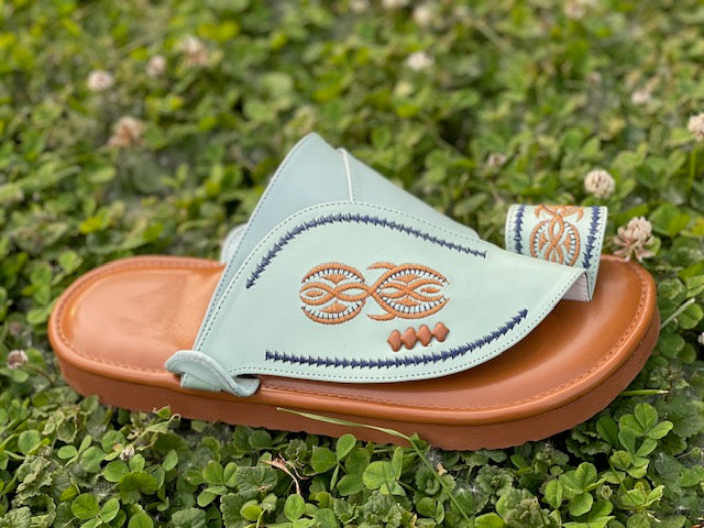 “Heritage Sandal in mint green leather featuring beautifully embroidered orange and navy blue stitching