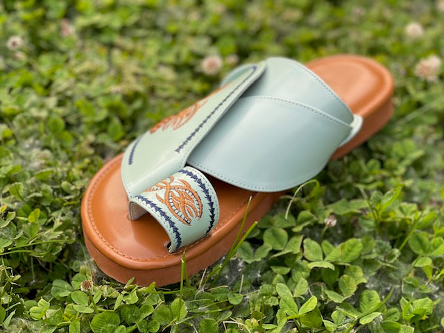 “Heritage Sandal in mint green leather featuring beautifully embroidered orange and navy blue stitching