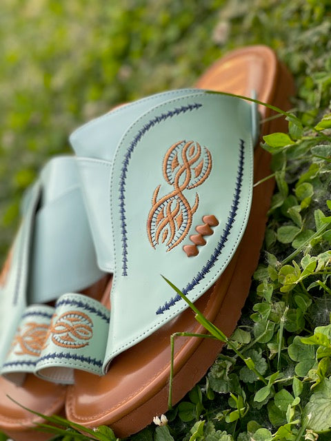 “Heritage Sandal in mint green leather featuring beautifully embroidered orange and navy blue stitching